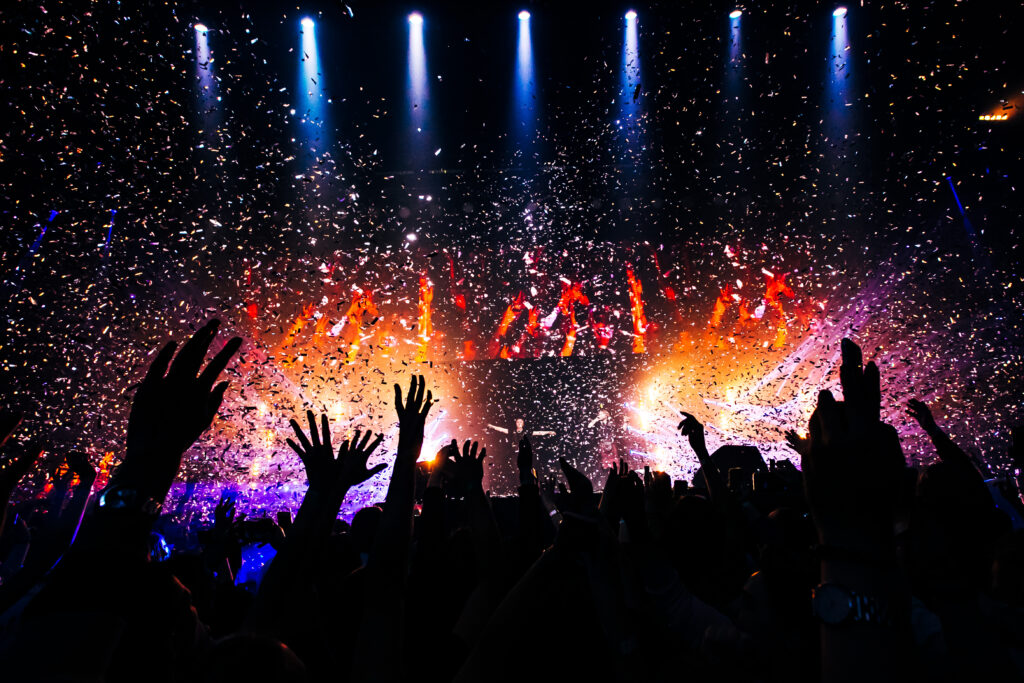 Fans hands raised up during the show. Bright lights and shiny co